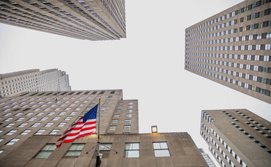 Fototapete - New York, Manhattan. High buildings view from below against blue sky background