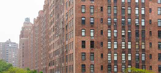Fototapete - New York, Manhattan Chelsea area. Brick wall facade skyscrapers against cloudy sky background