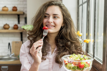 Wall Mural - Brunette woman eating a salad