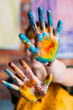 © golubovy - Creative hobby. Female artist showing hands dirty with blue and yellow paint. Blur background.