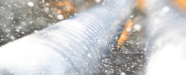 Metal pipeline in the street on a snowy day