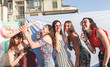 group of female friends having fun with party accessories on the roofs