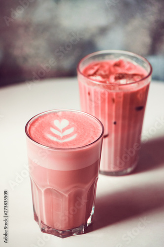 Two trendy beetroot lattes with latte art on table in cafe. Poster Mural XXL