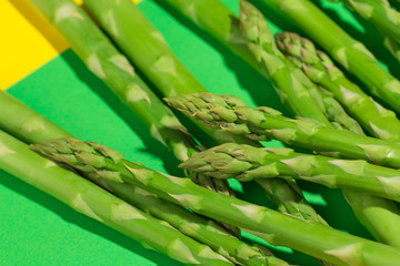 green raw asparagus on green color paper