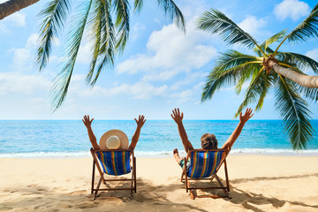 Wall Mural - Happy couple with arms up relax on the beach enjoy beautiful sea on the tropical island