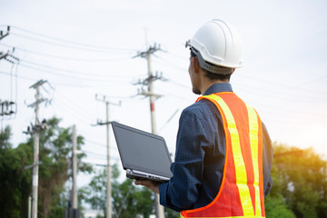 Engineering Holding Notebook inspects the wires on the electrical pole.