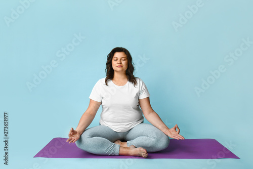 Cuadros en Lienzo Beautiful plus size woman meditating on color background