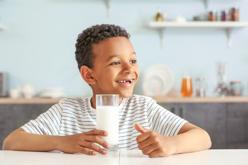 Wall Mural - Cute African-American boy with glass of milk at table