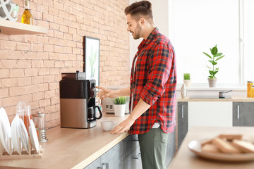 Sticker - Handsome man using coffee machine in kitchen