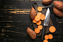 Cutting Board And Knife With Raw Sweet Potato On Wooden Background