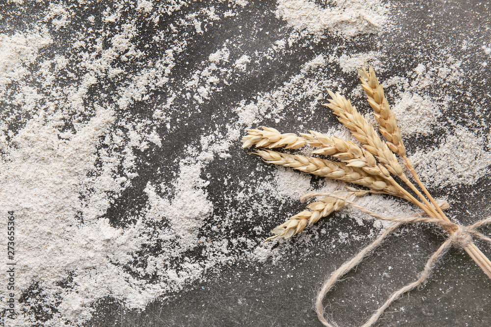 Flour with wheat ears on grey background