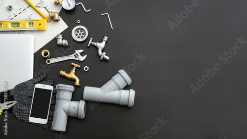 Fotografía Mobile phone with plumbing items on dark background