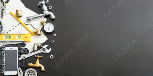 Fotografía Mobile phone with plumbing items on dark background