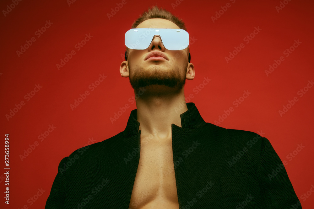 Muscle strong face beautiful stripped male model in casual look with denim and suit wearing glasses on bordo red isolated font background - obrazy, fototapety, plakaty 