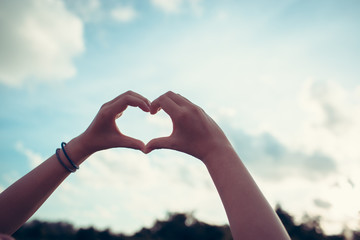 Hand on heart-shaped bokeh background blurred, natural tones vintage style. Show the world you love Love Family between two people.Let's Stay Together happy mother's day,