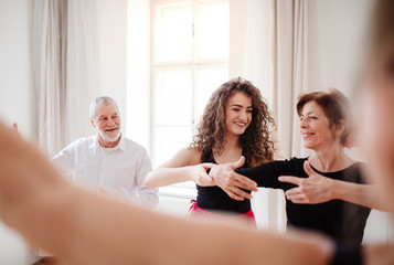 Group of senior people in dancing class with dance teacher.