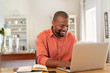 © Rido - Happy mature black man using laptop