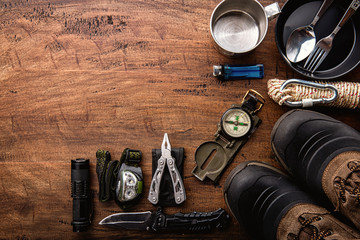 outdoor travel equipment planning for a mountain trekking camping trip on wooden background. top vie