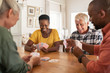 © Rido - Mature friends playing cards at home