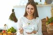 © rogerphoto - Young happy woman cooking in the kitchen. Healthy meal, lifestyle and culinary concepts. Good morning begins with fresh salad