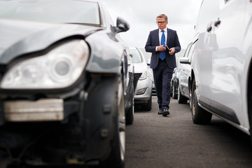 Wall Mural - Male Insurance Loss Adjuster With Digital Tablet Inspecting Damage To Car From Motor Accident