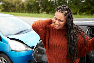 Female Motorist With Whiplash Injury In Car Crash Getting Out Of Vehicle