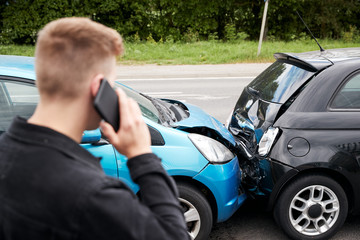 Wall Mural - Young Male Motorist Involved In Car Accident Calling Insurance Company Or Recovery Service