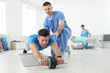 © New Africa - Professional physiotherapist working with male patient in rehabilitation center