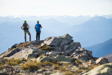 Two Climbers Stand On The Summit Of Douglas Peak, British Columbia.