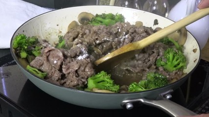 Wall Mural - Stirring flour into beef and broccoli in a pan