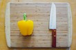 © Shubby Studio - yellow pepper and knife on on a wooden board