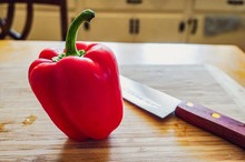 Red Pepper And Knife On Cutting Board