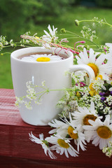 A cup with floral natural chamomile tea