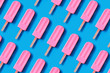 Pattern made of bright pink strawberry ice cream on blue pastel background.