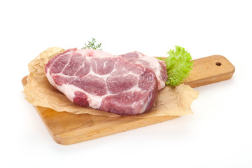 Raw pork steak over wooden board