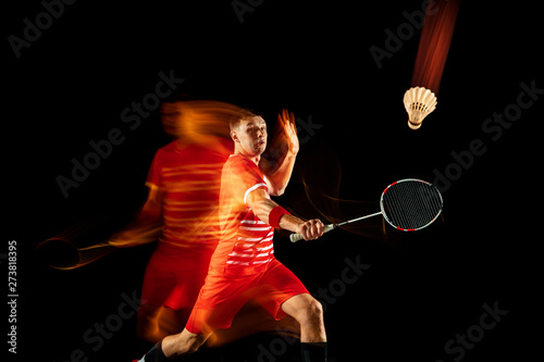 Plakaty Badminton  mlody-czlowiek-gra-w-badmintona-na-bialym-tle-na-czarnym-tle-w-mieszanym-swietle-meski-model-z
