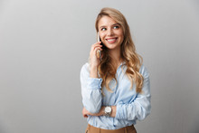Photo of caucasian blond businesswoman with long curly hair smiling and calling on smartphone