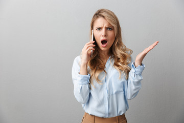 Poster - Photo of perplexed blond businesswoman with long curly hair worrying while calling on smartphone