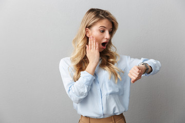 Sticker - Photo of concerned blond businesswoman with long curly hair worrying while looking at wristwatch