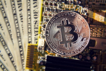 Wall Mural - silver bitcoin coin with dollars and computer motherboard, cryptocurrency mining and investing conce