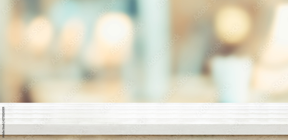 Empty white wood table and blurred soft light table in restaurant with ...