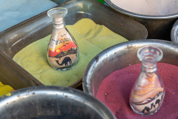 Wall Mural - Souvenirs from Jordan - bottles with sand and shapes of desert and camels.