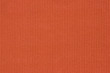 Ribbed textile material, in fine-knit stretch fabric. Knitwear texture. Burnt orange color background.