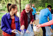 © Halfpoint - Group of fit people picking up litter in nature, a plogging concept.