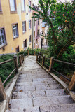 Fototapeta Na drzwi - Narrow city street with stairs in Budapest. Vertical view of an abandoned step lane in Hungary.