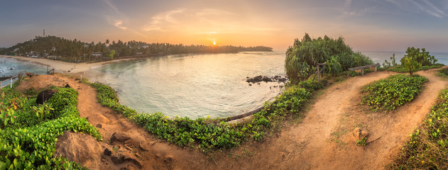 Wall Mural - tropical beach with rocks on sand coast of ocean