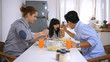 © S photographer - Family concept. The girl is eating food with her family.