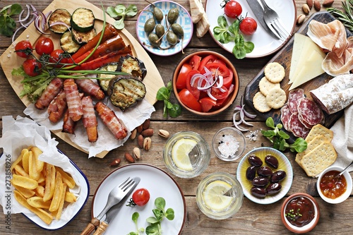 Fotografía Grill party table concept with grilled sausage, potato fries,vegetable,sappetizers and tomato salad