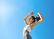 © vitaliymateha - Happy woman with tanned slim body and tattoo posing in sport wear against blue sky. Healthy smiling female enjoying sunny summer day. Summertime concept.