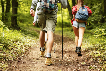 Wall Mural - people hiking.only legs and tracking boots are visible. rear view.